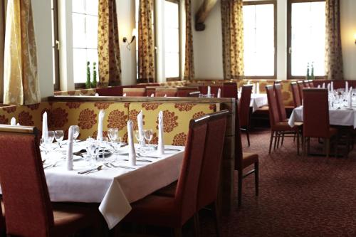 a dining room with white tables and chairs and windows at ROBINSON AMADÉ in Kleinarl
