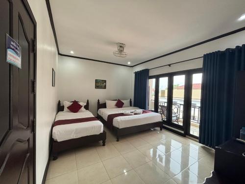 1 Schlafzimmer mit 2 Betten und einem Balkon in der Unterkunft Central Mountain View Hotel in Vang Vieng