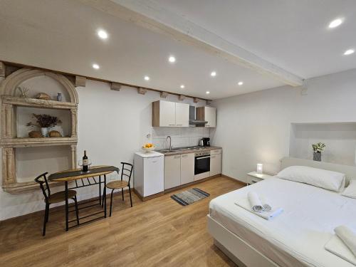 um quarto com uma cama, uma mesa e uma cozinha em Apartment Zakrjan in Old town Korčula em Korčula