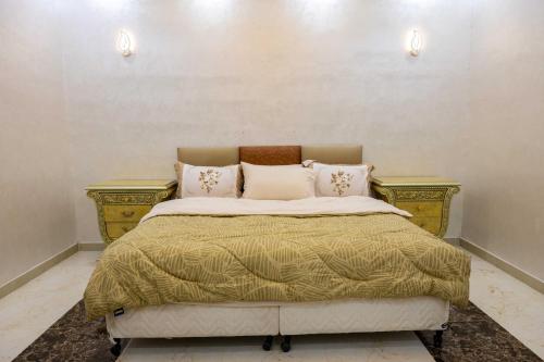 a bedroom with a bed with two night stands at Andalusia farm in Al Rahba