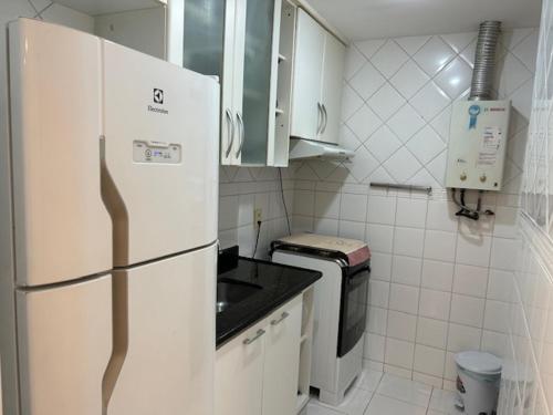 una cucina bianca con frigorifero e forno a microonde di Apto de 2 quartos e 2 banheiros sociais no Barramares a Rio de Janeiro