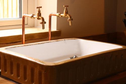 un lavandino in legno con due rubinetti in bagno di The Old Forge a Cheltenham