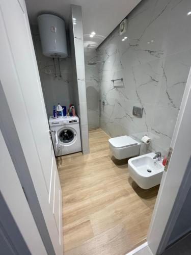 a bathroom with a white sink and a toilet at Luxury Rooftop Vlora in Vlorë