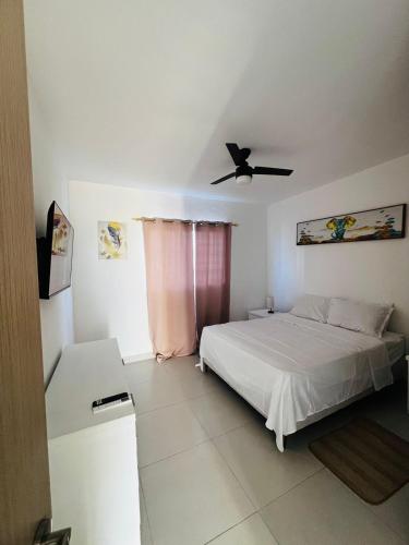 Schlafzimmer mit einem Bett und einem Deckenventilator in der Unterkunft La rose in Punta Cana