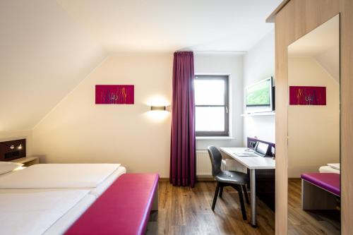 a hotel room with a desk and a bed at Weinhotel Restaurant Klostermühle in Ockfen