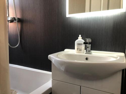 uma casa de banho com um lavatório branco e um chuveiro em Stunning 2 Bedroom Flat Next to Victoria Hospital em Fife