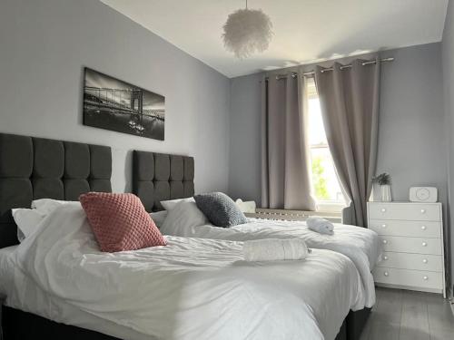 a bedroom with two beds and a window at Stunning 2 Bedroom Flat Next to Victoria Hospital in Fife