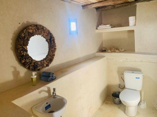 a bathroom with a toilet and a mirror on the wall at Momo's beach house in Aghnajane