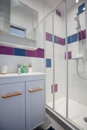 une salle de bain blanche avec une douche et un lavabo dans l'établissement 2 pièces Cosy - proche RER A - proche Paris, à Houilles