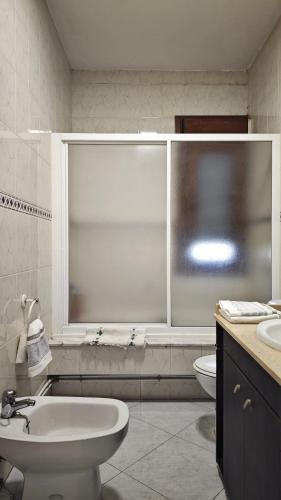 a bathroom with a sink and a toilet and a window at Casa Fenteira in Poio