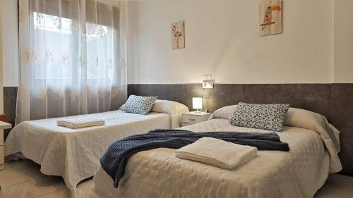 a bedroom with two beds and a window at Casa Fenteira in Poio