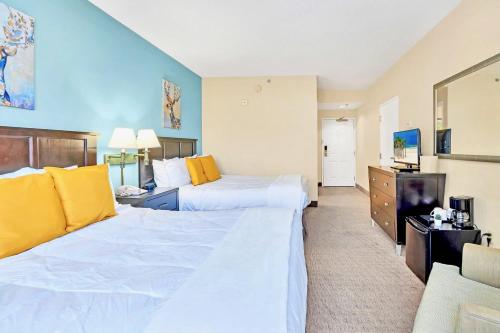 um quarto de hotel com duas camas e uma televisão em Apt Close to Universal Studios with Hot tub Pool em Orlando