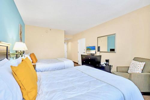 una camera d'albergo con due letti e una televisione di Apt Close to Universal Studios with Hot tub Pool a Orlando