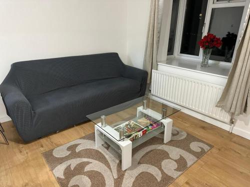 a living room with a black couch and a table at Charming Escape: 2BR Home with Parking in Aveley