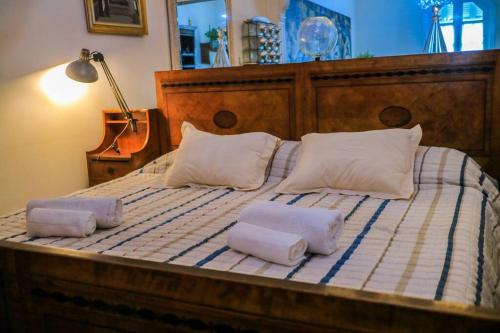 1 cama grande de madera con 2 almohadas en Sky Garden Sarandi [ SuperLoft ] Pool & Barbacue, en Montevideo