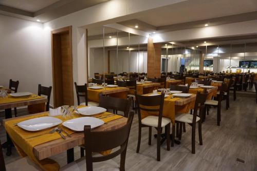 a restaurant with wooden tables and chairs and a large mirror at Antalya Ramona in Antalya
