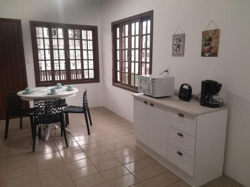 cocina con mesa y microondas en la barra en Casa Trindade UFSC, en Florianópolis