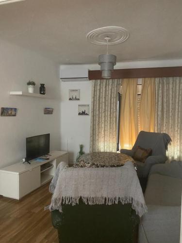 - un salon avec un lit et un canapé dans l'établissement apartamento turístico CUATRO CAMINOS, à San Vicente de Alcántara