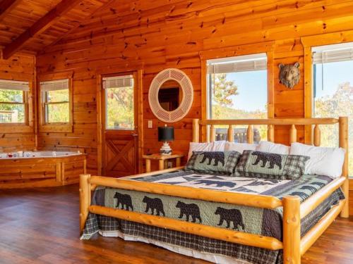 a bedroom with a bed in a log cabin at Grand Mountain View Lodge By Ghosal Luxury Lodging in Sevierville