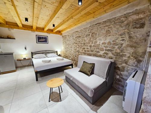 1 dormitorio con 2 camas y pared de piedra en Apartment Revelin in Old town Korčula, en Korčula