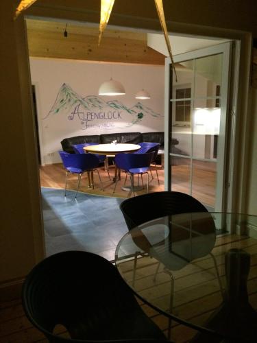 a dining room with blue chairs and a table at Alpenglück de Luxe Ferienwohnung am Forggensee in Schwangau