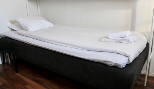 a bed with white sheets and towels on it at Sure Hotel by Best Western Vilsta Sporthotell in Eskilstuna