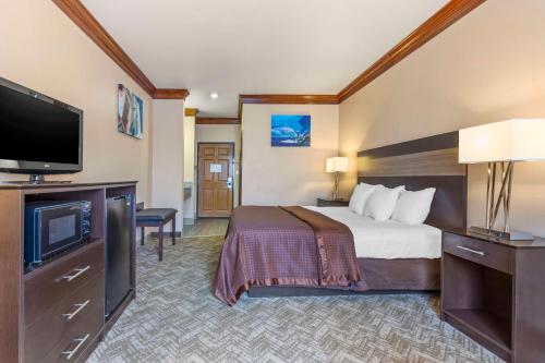 a hotel room with a bed and a flat screen tv at Best Western Fort Worth Inn & Suites in Fort Worth