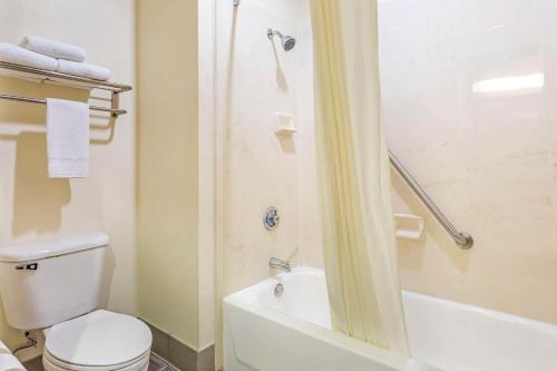 a bathroom with a white toilet and a shower at Best Western Fort Worth Inn & Suites in Fort Worth