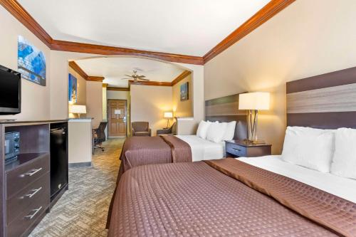 a hotel room with two beds and a flat screen tv at Best Western Fort Worth Inn and Suites in Fort Worth