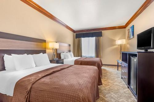 a hotel room with two beds and a flat screen tv at Best Western Fort Worth Inn & Suites in Fort Worth