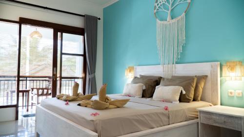 a bedroom with a bed with stuffed animals on it at The White Bay Lombok in Kuta Lombok