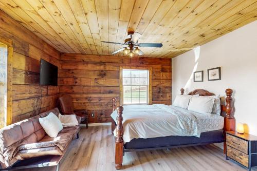 1 dormitorio con 1 cama y 1 sofá en Piney Hollow - Unit B, en Hendersonville