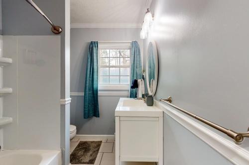 a white bathroom with a sink and a mirror at Half Moon Cottage in Jacksonville
