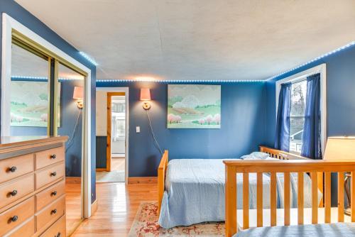 a blue bedroom with a bed and a crib at Classic Waterfront Home on Lake Maspenock with Grill in Hopkinton