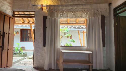 a window with a white curtain in a room at Majestic Coffee Hotel and Restaurant Tierradentro in Tierra Adentro