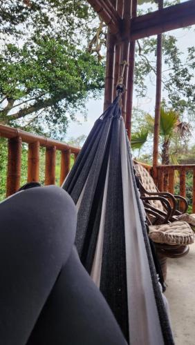 a hammock on the porch of a house at Majestic Coffee Hotel and Restaurant Tierradentro in Tierra Adentro