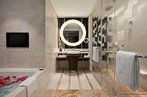 a bathroom with a tub and a sink and a mirror at Kempinski Hotel Chongqing in Chongqing