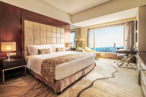 sypialnia z dużym łóżkiem i dużym oknem w obiekcie Kempinski Hotel Chongqing w mieście Chongqing