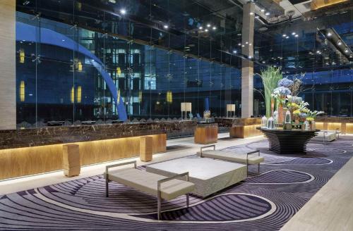 eine Lobby mit Sofas und einem Tisch in einem Gebäude in der Unterkunft Hotel Indonesia Kempinski Jakarta in Jakarta
