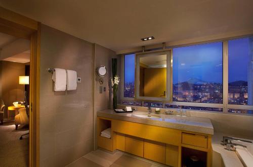 a bathroom with a sink and a window with a city view at Kempinski Hotel Dalian in Dalian