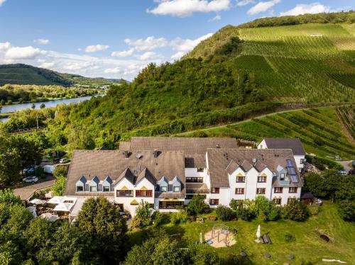 an aerial view of a house in the hills with a river at Weinhotel Restaurant Klostermühle in Ockfen