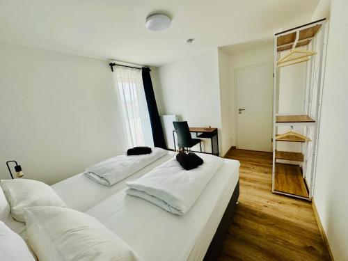 a white bedroom with two beds and a mirror at 3BR stay close to Munich City & Airport in Oberschleißheim