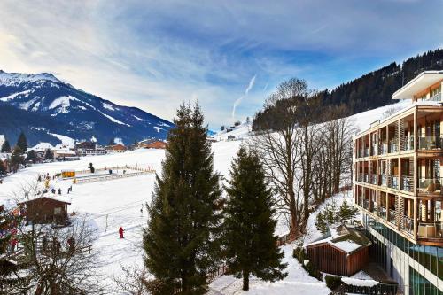 ein Skigebiet mit einer Skipiste und einem Gebäude in der Unterkunft Kempinski Hotel Das Tirol in Jochberg
