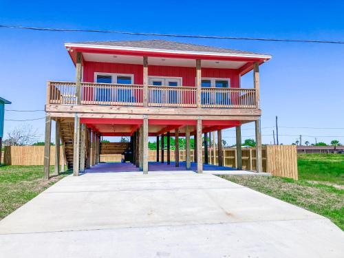 a large red house with a deck on top at Red Fish, Blue Fish in Aransas Pass