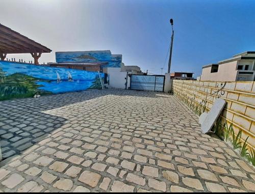 uma passagem de pedra com dois bancos ao lado de uma cerca em Villa piscine 4 chambres em Hanshīr Qaşr Ghallāb