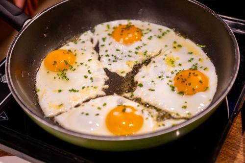 two eggs frying in a pan on the stove at Weinhotel Restaurant Klostermühle in Ockfen