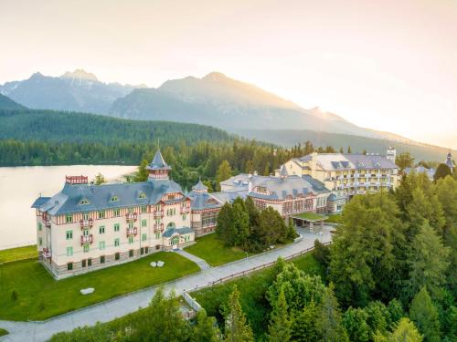 - une vue aérienne sur un complexe avec un lac et des montagnes dans l'établissement Grand Hotel Kempinski High Tatras, à Štrbské Pleso