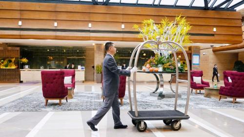 Un homme en costume se promène devant une table dans le hall dans l'établissement Kempinski Hotel Beijing Yansha Center, à Pékin