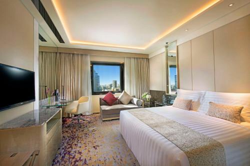 Kempinski Hotel Beijing Yansha Center في بكين: غرفه فندقيه سرير كبير وتلفزيون