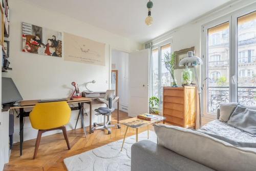 un salon avec un bureau et un canapé dans l'établissement Bel appartement cosy, emplacement idéal, à Paris
